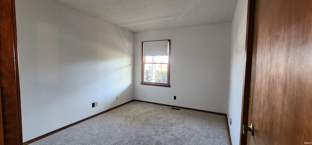 spare room with a textured ceiling and light colored carpet