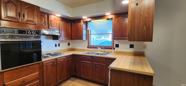 kitchen featuring black oven, sink, and stainless steel gas cooktop