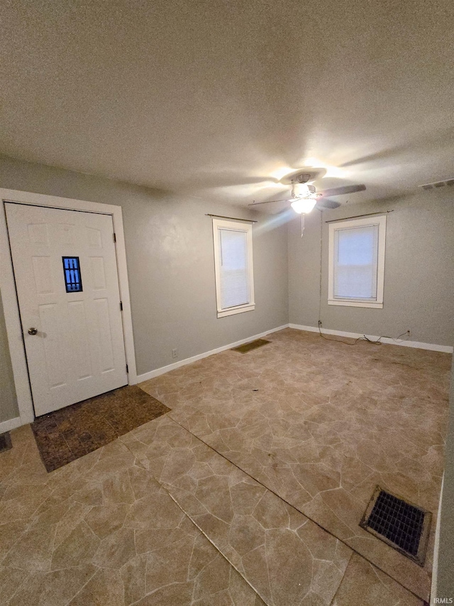 entryway featuring a textured ceiling and ceiling fan