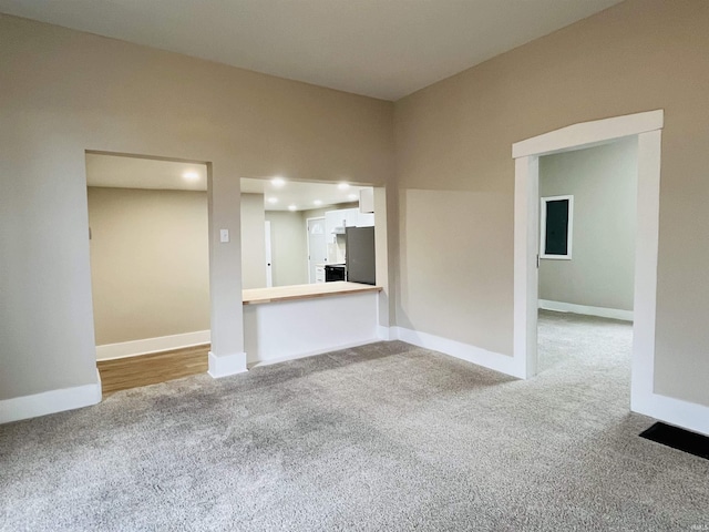 unfurnished living room with light colored carpet