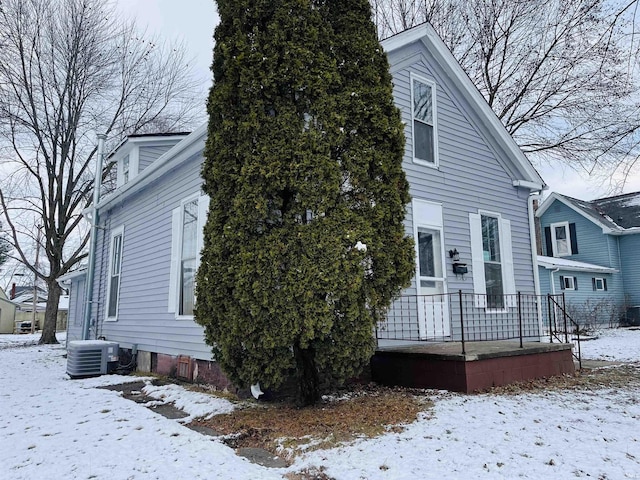 view of snowy exterior featuring central AC