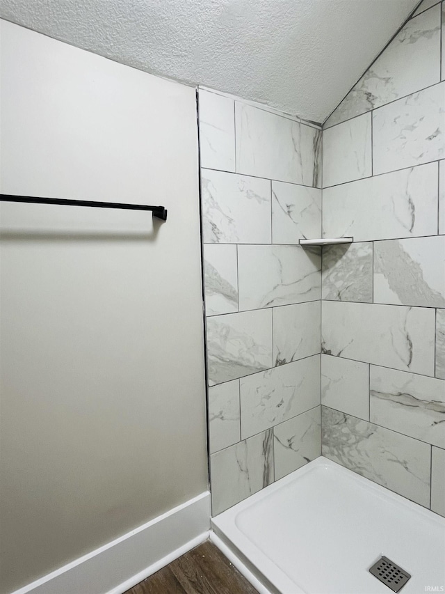 bathroom with a shower, hardwood / wood-style floors, and a textured ceiling