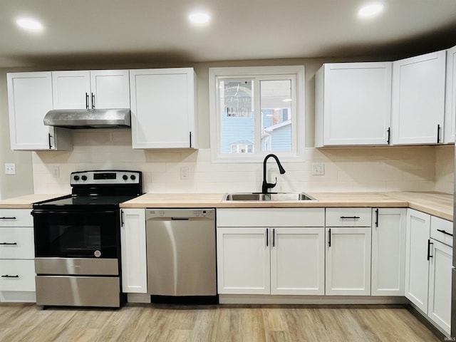 kitchen featuring white cabinetry, sink, stainless steel appliances, and light wood-type flooring