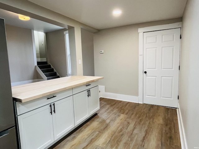 kitchen with white cabinetry, light hardwood / wood-style flooring, and wooden counters