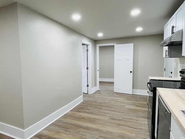 kitchen with light hardwood / wood-style floors, range with electric stovetop, and white cabinetry