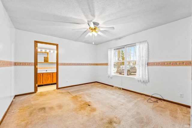 empty room with light carpet, a textured ceiling, and ceiling fan