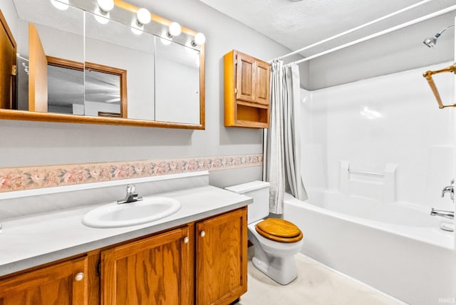 full bathroom featuring vanity, toilet, shower / bath combo with shower curtain, and a textured ceiling