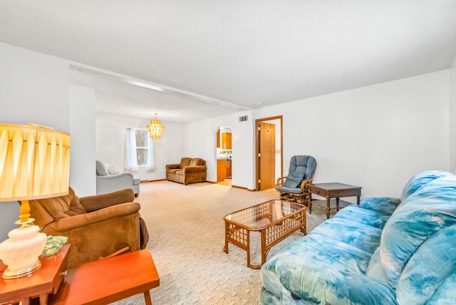 carpeted living room featuring a chandelier