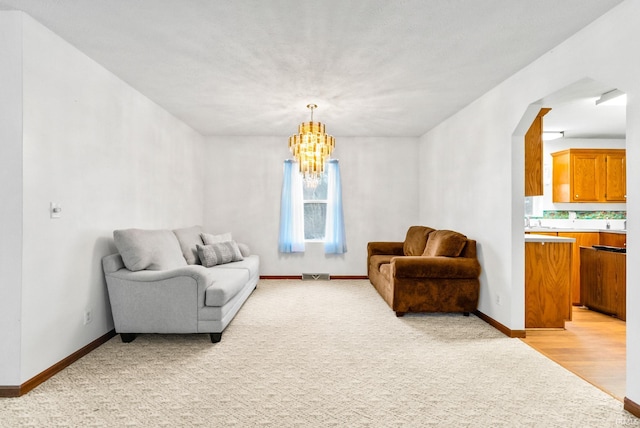 living room with light wood-type flooring and a notable chandelier