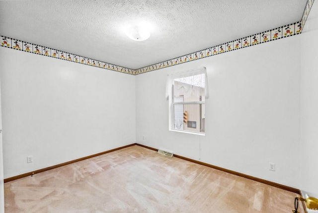 carpeted spare room with a textured ceiling