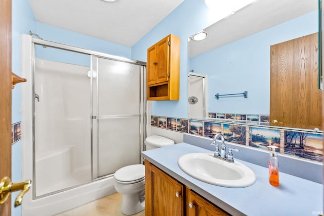 bathroom featuring vanity, toilet, and a shower with shower door