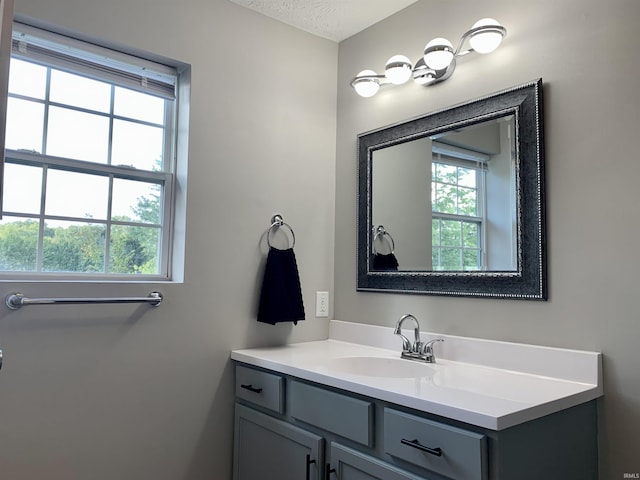 bathroom with plenty of natural light, a textured ceiling, and vanity