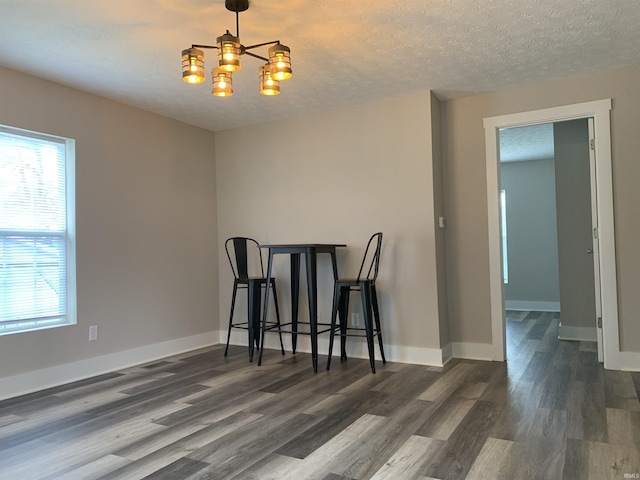 dining space featuring a wealth of natural light, dark hardwood / wood-style floors, and an inviting chandelier