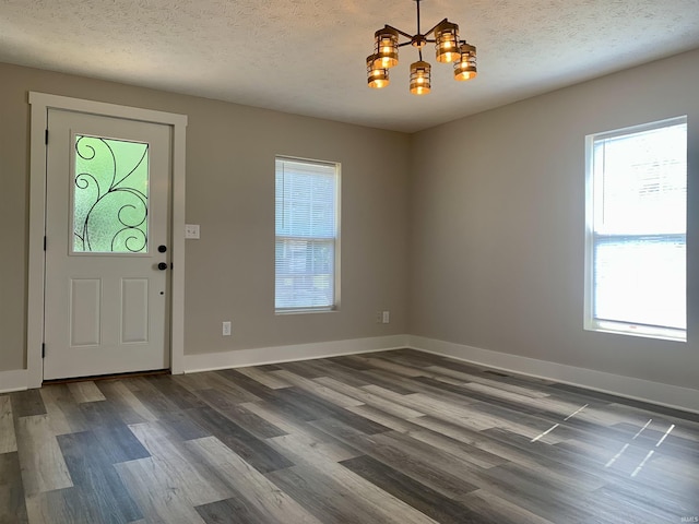 entryway featuring dark hardwood / wood-style floors, a chandelier, and a textured ceiling