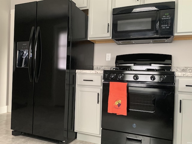 kitchen with black appliances, white cabinets, and light tile patterned floors