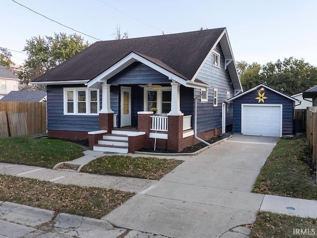 view of front of home featuring covered porch, a garage, and an outbuilding