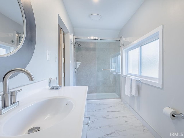 bathroom featuring a shower with door and vanity