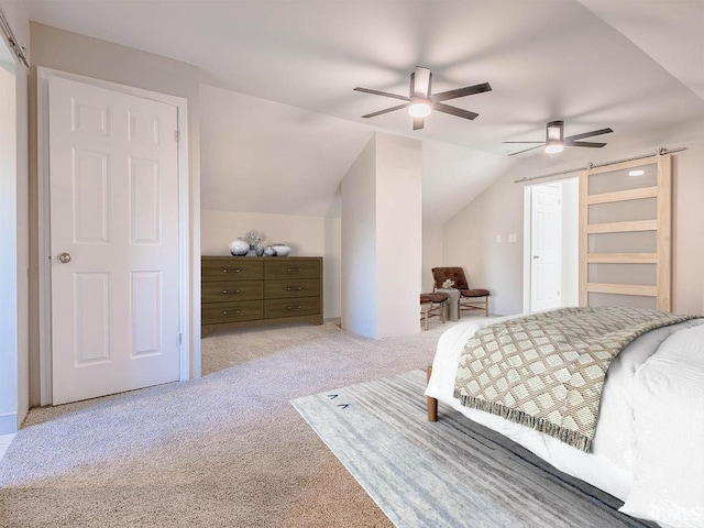 carpeted bedroom featuring ceiling fan, a barn door, and lofted ceiling