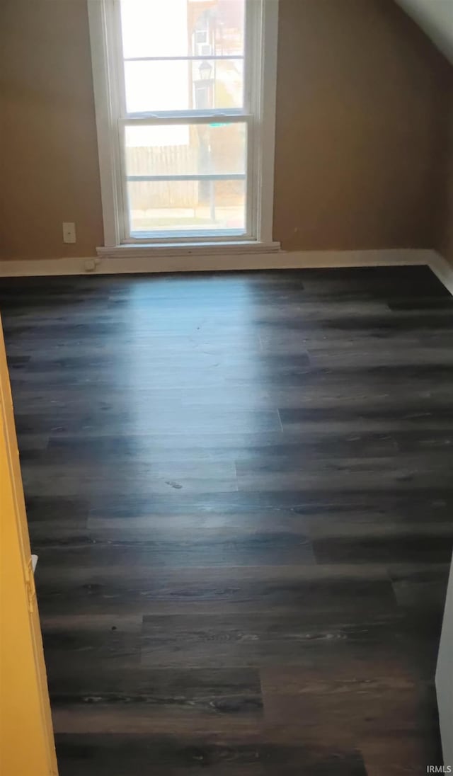 additional living space with dark hardwood / wood-style floors and lofted ceiling