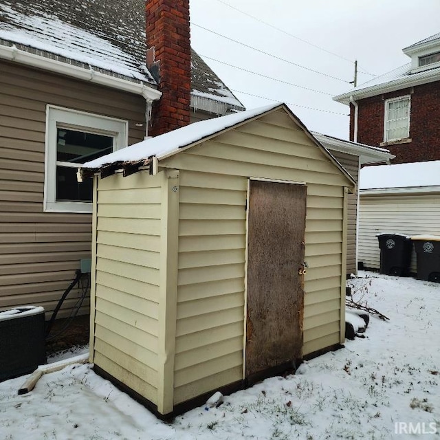 snow covered structure featuring cooling unit