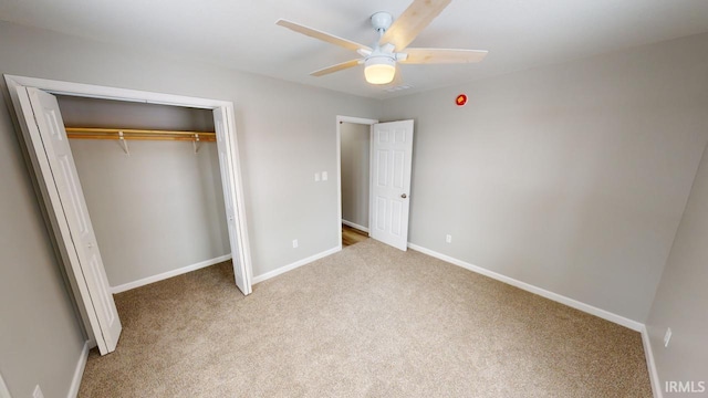 unfurnished bedroom featuring ceiling fan, light carpet, and a closet