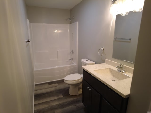 full bathroom with washtub / shower combination, wood-type flooring, vanity, and toilet