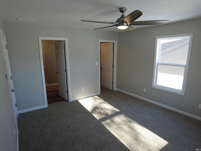 unfurnished bedroom with connected bathroom, ceiling fan, and dark carpet