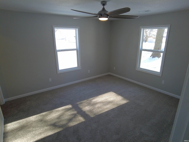 carpeted spare room featuring plenty of natural light and ceiling fan