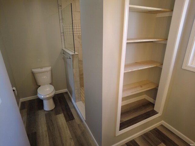 bathroom with a shower, hardwood / wood-style flooring, and toilet