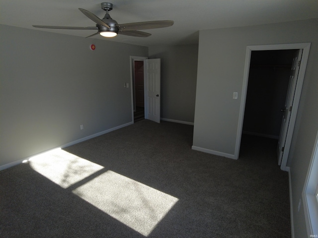 empty room with ceiling fan and dark carpet