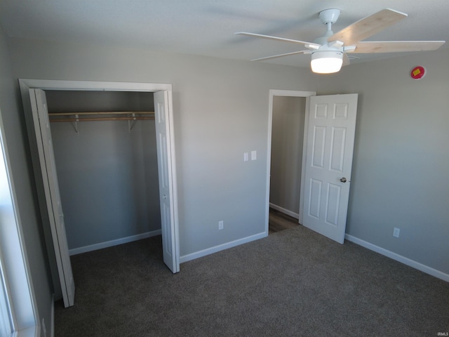 unfurnished bedroom with ceiling fan, dark carpet, and a closet