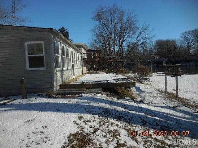 yard layered in snow featuring a wooden deck