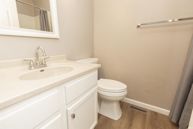 bathroom featuring a shower with shower curtain, vanity, wood-type flooring, and toilet