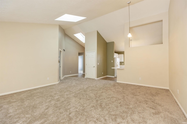 spare room featuring carpet and vaulted ceiling with skylight