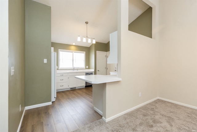 kitchen with dishwasher, hanging light fixtures, kitchen peninsula, a breakfast bar, and white cabinets