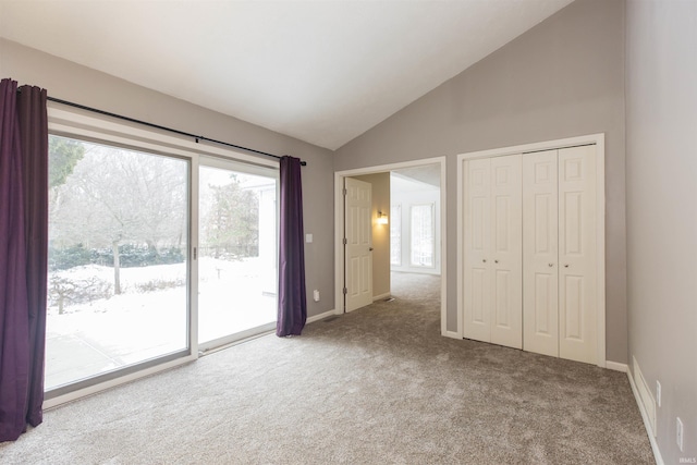 unfurnished bedroom featuring access to exterior, carpet flooring, a closet, and lofted ceiling