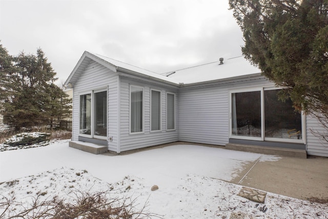 snow covered property featuring a patio