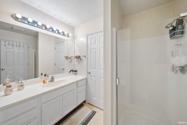 bathroom featuring vanity, a textured ceiling, and walk in shower