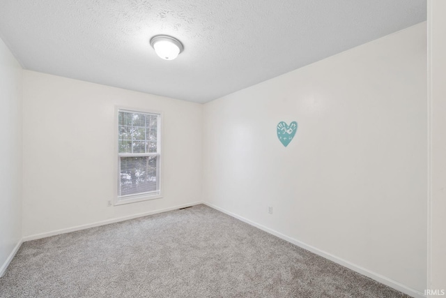 carpeted spare room with a textured ceiling