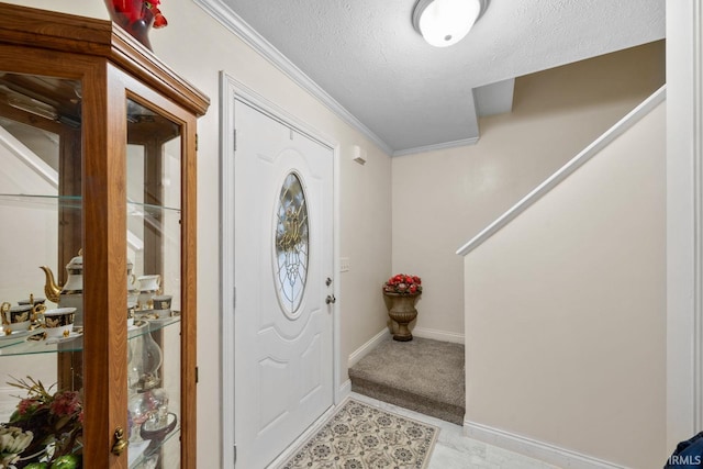 carpeted foyer with a textured ceiling and crown molding