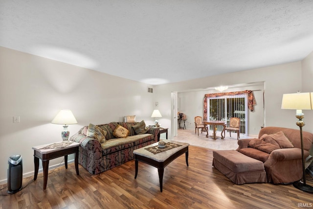 living room with wood-type flooring and a textured ceiling