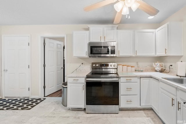 kitchen featuring ceiling fan, white cabinetry, sink, and appliances with stainless steel finishes