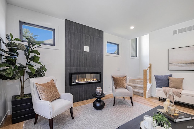 sitting room with light wood-type flooring and a large fireplace