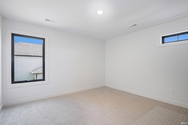 unfurnished room with a healthy amount of sunlight and light carpet