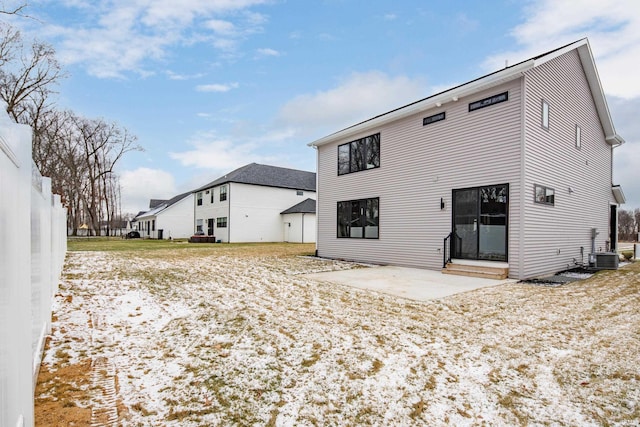 snow covered property featuring a patio and central AC unit