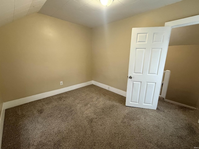 interior space featuring vaulted ceiling, carpet flooring, and baseboards