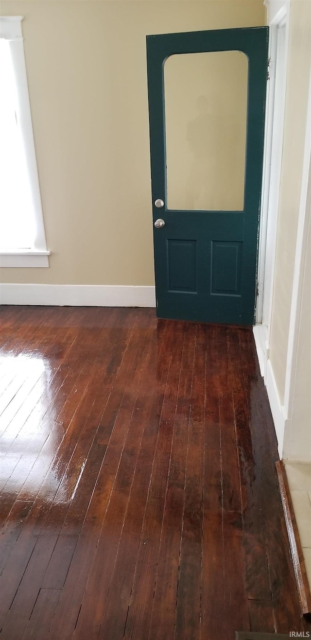 entryway with dark wood-style floors and baseboards