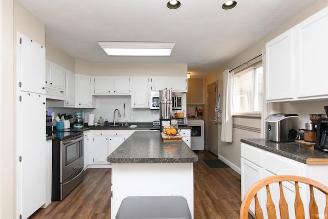 kitchen featuring white cabinets, dark hardwood / wood-style floors, a kitchen island, and electric stove