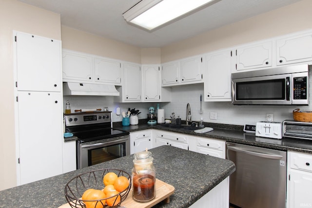 kitchen with white cabinets, stainless steel appliances, tasteful backsplash, and sink