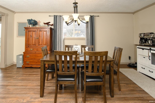 dining area featuring a chandelier, hardwood / wood-style floors, a textured ceiling, and crown molding